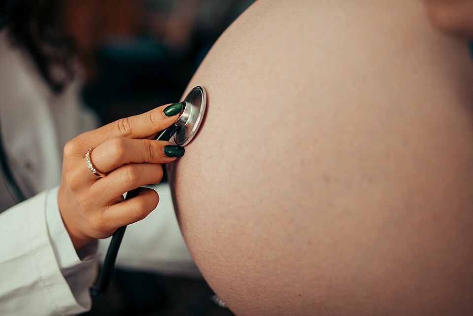 A stethoscope on a pregnant belly