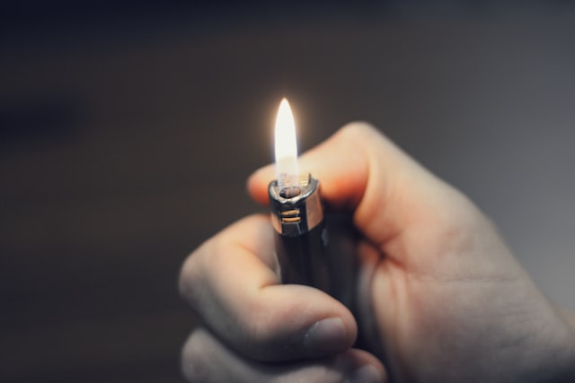 person holding a lit black lighter