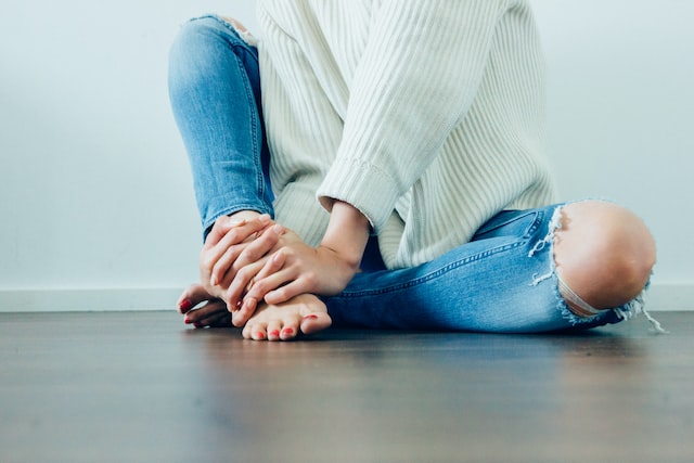 woman sitting on the floor with knee exposed