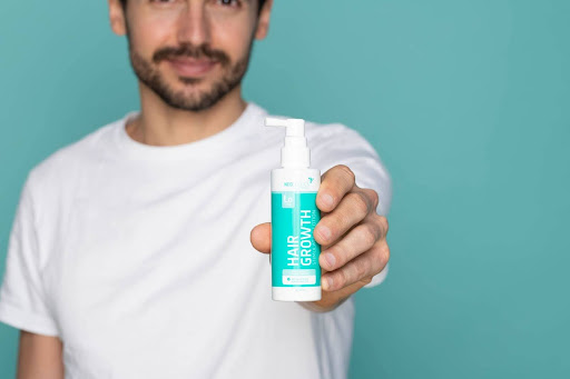guy holding neofollicss bottle
